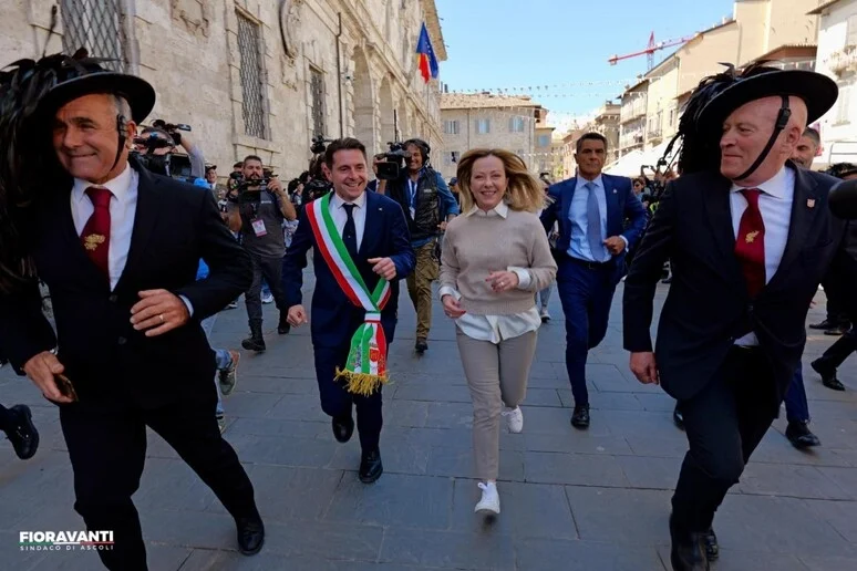 Performance della Meloni in corsa con i Bersaglieri, da bimbi in dono 'cappello per la pace'